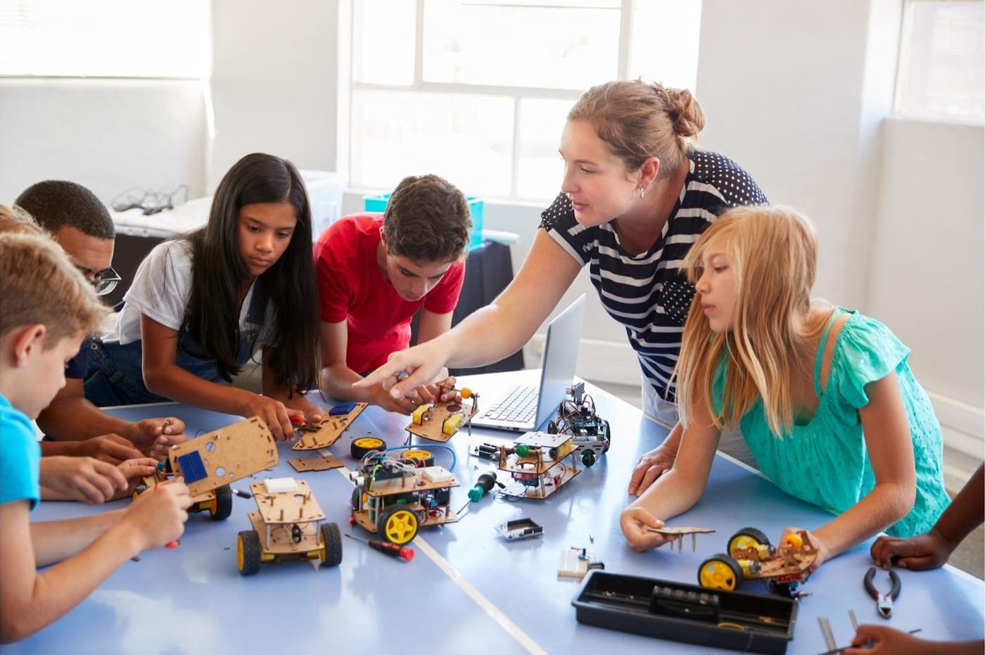 A teacher helping a group of students with a classroom project